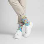 Load image into Gallery viewer, Person wearing colorful polka dot socks with white sneakers on a light  blue  background, yellow band and toe by Cole + Parker
