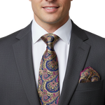 Load image into Gallery viewer, Man wearing a rich silk paisley tie with navy blue,  pink and gold tones and matching pocket square. 

