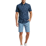 Charger l'image dans la galerie, Man wearing a navy paisley patterned short sleeve shirt with light blue shorts 
