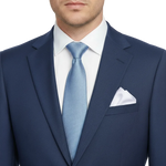 Charger l'image dans la galerie, Man wearing a navy suit with a light blue tie and white pocket square on 
