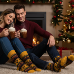 Load image into Gallery viewer, Couple enjoying hot chocolate in front of a fireplace with Christmas decorations wearing their comfortable and warm Viyella Reindeer Pattern Socks. 
