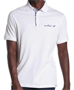 Load image into Gallery viewer, Close up of Our model is wearing a white Cotton Polo Shirt  with blue and white floral trim on the false pocket
